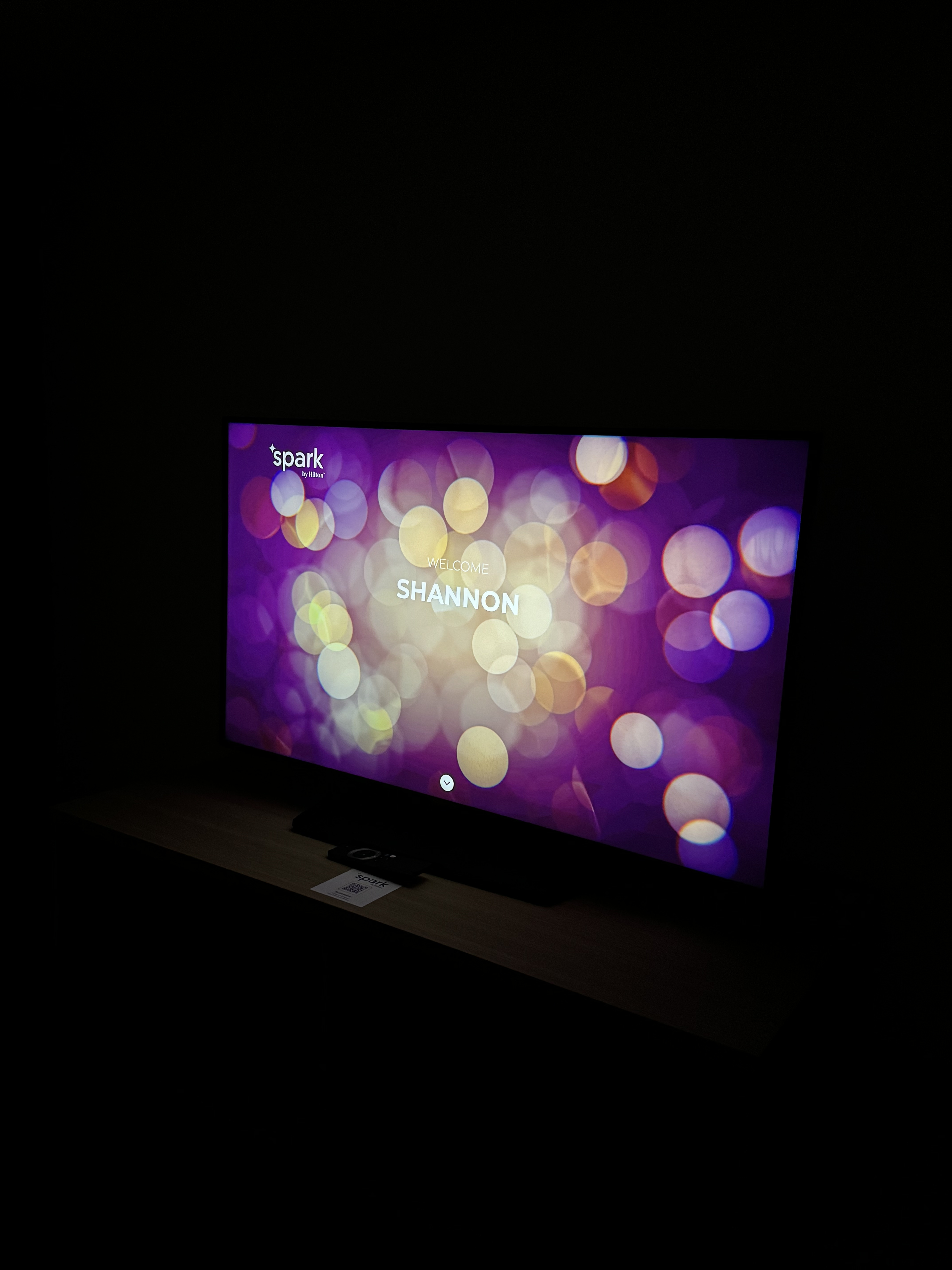 A flatscreen TV showing the words 'Welcome, Shannon' with a flowery background.