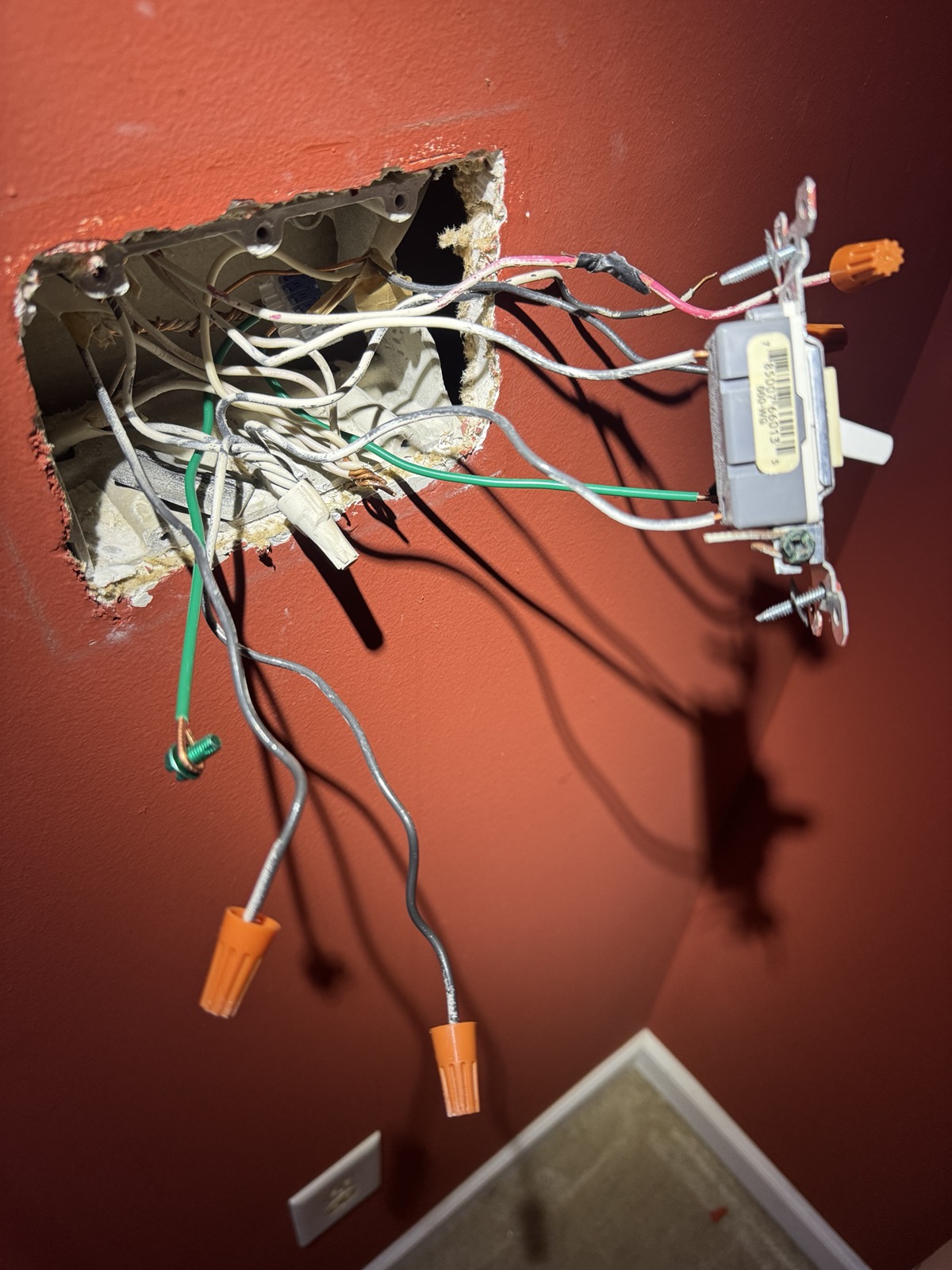 iPhone camera photo of an open 3-gang junction box on a wall, with wires chaotically spilling out like tentacles from some kind of [Eldrazi horror](https://mtg.fandom.com/wiki/Eldrazi).